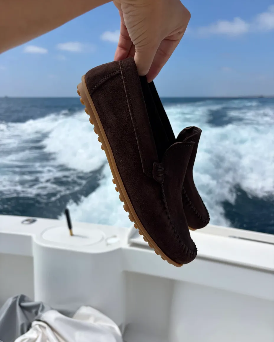 Mocasines de gamuza café sobre el mar